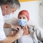 doctor adjusting implantable port on woman