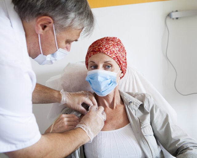 doctor adjusting implantable port on woman