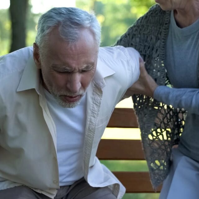 woman helping man suffering from hernia stand up