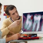 doctor and patient looking at tooth decay on xray